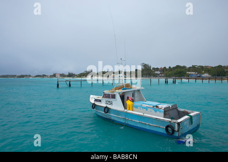 Bateau de pêche au quai de pêche de la baie d'Oistins, côte sud de la Barbade, Eglise paroissiale de Christ Banque D'Images