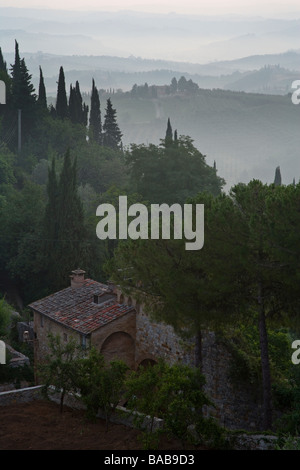 Paysage brumeux à l'aube vu des murs de la ville de San Gimignano, Toscane, Italie. Banque D'Images