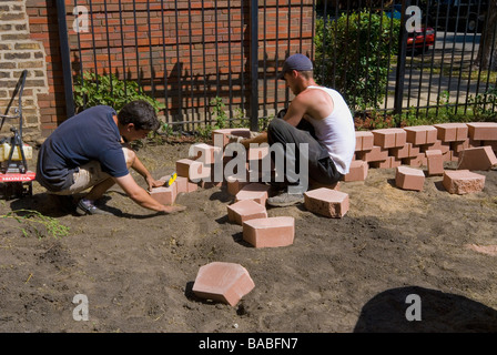 L'aménagement paysager et de l'architecte italien hispanique pose helper pour pavés soulevés jardin fleuri pour un immeuble Banque D'Images