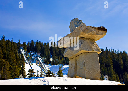 Inukshuk en pierre avec sauts de ski en arrière-plan,Vallée Callaghan,Canada. Banque D'Images