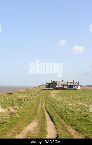 L'érosion côtière près de Waxham,North Norfolk, Angleterre, Royaume-Uni. Des maisons abandonnées sur le bord de la falaise avec des jardins de tomber dans la mer. Banque D'Images