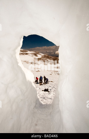 Un groupe d'alpinistes sur les trous de neige bâtiment dans le Cairngorm Parc national de Cairngorm en Ecosse UK Banque D'Images