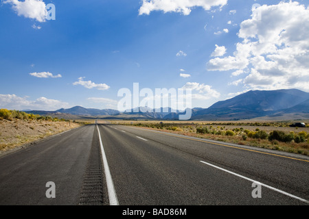 Route sans fin sur l'autoroute, avec un ciel bleu et nuages Banque D'Images