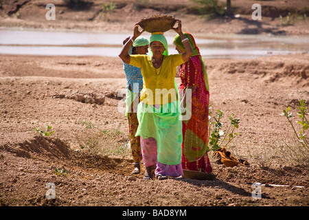 Femme transportant des conteneurs ouvrier sur sa tête du sol, Keechen, près de Phalodi,, Rajasthan, Inde Banque D'Images