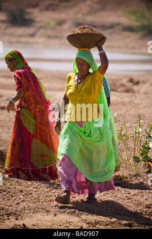 Femme transportant des conteneurs ouvrier sur sa tête du sol, Keechen, près de Phalodi,, Rajasthan, Inde Banque D'Images