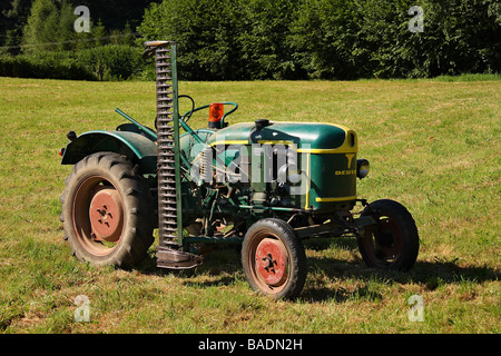 Un livre vert et jaune 1959 Tracteur Deutz F1 monté sur le côté avec la faucheuse d'herbe dans un champ Limousin France Banque D'Images