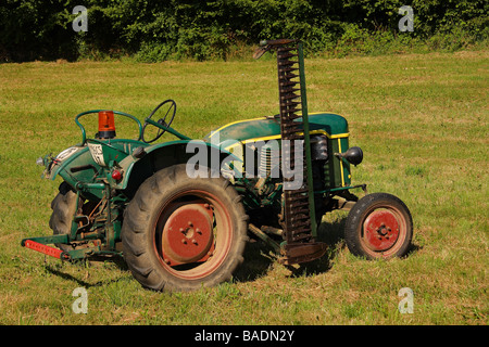 Un livre vert et jaune 1959 Tracteur Deutz F1 monté sur le côté avec la faucheuse d'herbe dans un champ. Limousin France Banque D'Images