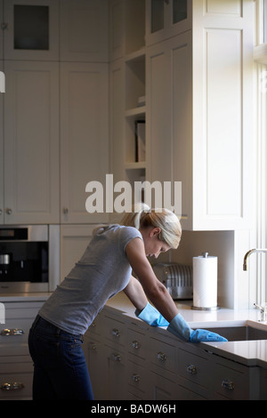 Woman Leaning on évier de cuisine Banque D'Images