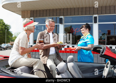 Waitress Serving Couple dans la convertible à un rétro Diner, Niagara Falls, Ontario, Canada Banque D'Images