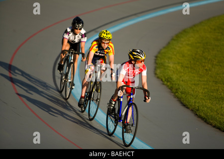 L'ILLINOIS Northbrook trois jeunes cyclistes masculins en course cycliste à piste vélodrome Banque D'Images