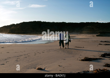 Couple walking along beach Banque D'Images