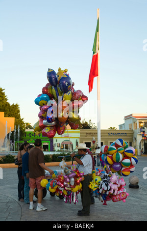 Mexique San Jose del Cabo homme vendeur de rue, la vente de ballons et de jouets dans Plaza Mirales drapeau mexicain sur pôle centre-ville d'affaires Banque D'Images