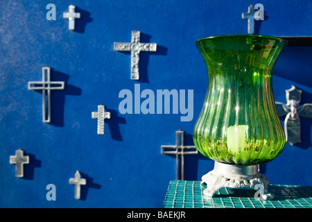 Todos Santos AU MEXIQUE Mexicain argent traverse accroché sur un mur bleu vert à l'extérieur sur globe de verre bougie sur plateau en carreaux de céramique Banque D'Images