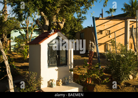 Mexique La Playita de culte de la Vierge Marie avec angel figurines en jardin à côté d'house en petite ville Banque D'Images