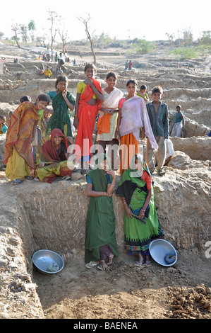 Les femmes et les enfants de la tribu des Garasia au Gujarat, creusant des tranchées pour l'eau d'un système d'irrigation dans le désert près de Poshina Banque D'Images