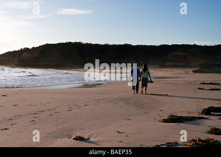 Couple en train de marcher le long d'une plage Banque D'Images