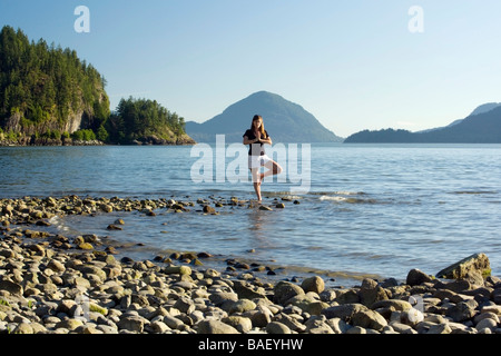 Young woman doing yoga pose au Parc Provincial Porteau Cove - près de Vancouver, Colombie-Britannique Banque D'Images