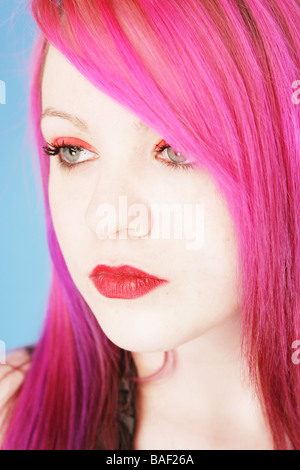 Head shot of a dix-huit ans avec goth cyber peau pâle et les cheveux rouges et rouge à lèvres Banque D'Images