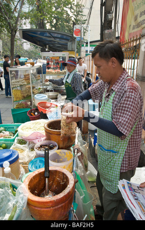 Un vendeur de rue la préparation de salade de papaye ou SomTam Bangkok Thaïlande Banque D'Images