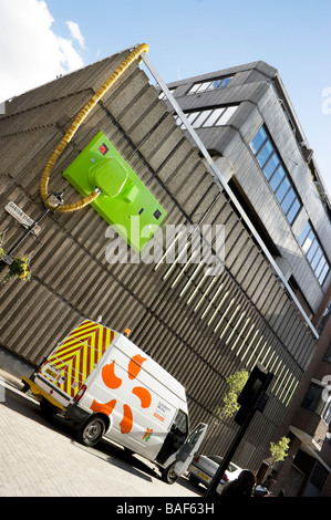 Réparation Électricité van à l'extérieur d'un bâtiment dans le centre de Londres. La construction semble avoir un géant et le socket sur son mur extérieur Banque D'Images