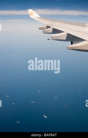 Un avion survolant le golfe Persique près de Dubaï avec une flotte de pétroliers ci-dessous laissant les champs pétroliers du Golfe Banque D'Images