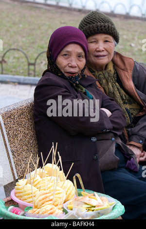 Vendeurs de fruits sur des bancs de parc le long du lac Hoan Kiem à Hanoi Vietnam Banque D'Images