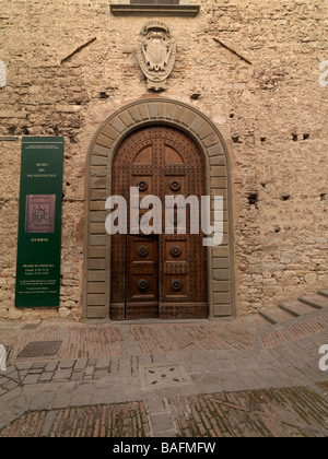 Une porte en bois sculpté trouvé sur une ancienne rue pavée de la ville de Gubbio, Italie. Banque D'Images