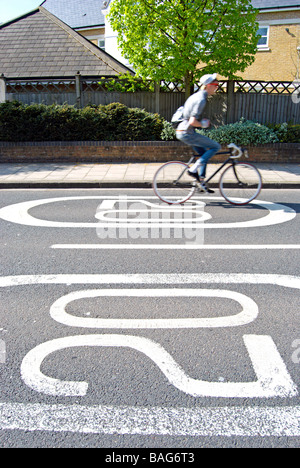 Le marquage routier britannique indiquant 20 milles à l'heure limite de vitesse, avec l'aide de mains pas cycliste de passage Banque D'Images