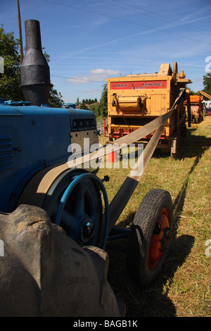 Un Lanz Bulldog tracteur roulant une ancienne batteuse ciel bleu au-delà Limousin France Banque D'Images