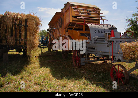 Un Lanz Bulldog tracteur roulant une vieille machine et la mise en balles de battage Banque D'Images