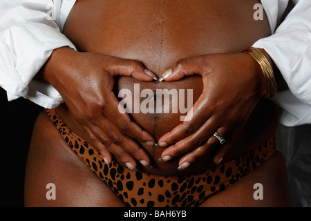 Femme enceinte avec des mains en forme de coeur Banque D'Images