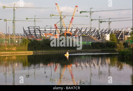 Les travaux de construction en cours sur le Stade Olympique, avec un canoteur, vu du fleuve Lee, Londres. UK. Banque D'Images