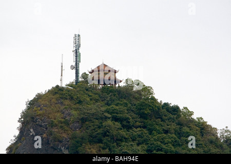 Karast calcaire surmonté d'une structure ancienne et moderne de la tour de téléphonie cellulaire en Baie d'Ha Long Vietnam Banque D'Images