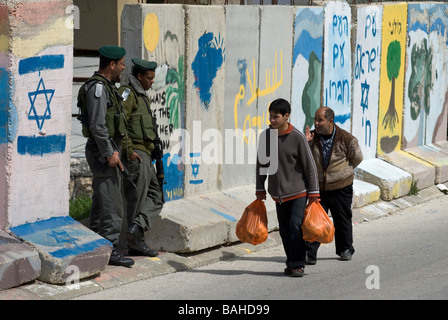 Les hommes palestiniens marchant le long de la dalle séparant un quartier palestinien de Bab-Zawiya et H-2 zone de contrôle israélien à Hébron Cisjordanie Banque D'Images