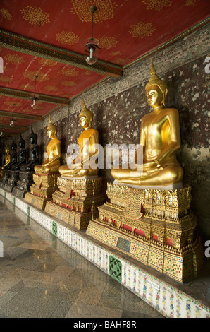 Statues de Bouddha en or la ligne galeries qui entourent le bâtiment principal de Wat Suthat à Bangkok en Thaïlande Banque D'Images