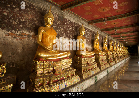 Statues de Bouddha en or la ligne galeries qui entourent le bâtiment principal de Wat Suthat à Bangkok en Thaïlande Banque D'Images