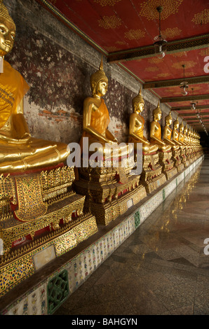 Une rangée de statues de Bouddha en or la ligne des galeries à Wat Suthat temple à Bangkok en Thaïlande Banque D'Images