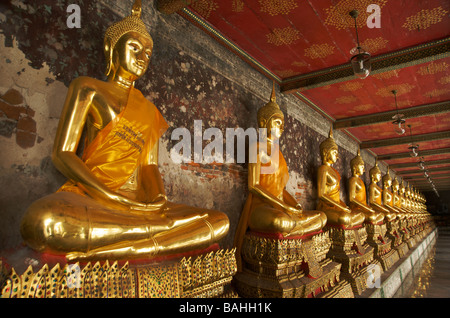 Une rangée de statues de Bouddha en or la ligne des galeries à Wat Suthat temple à Bangkok en Thaïlande Banque D'Images