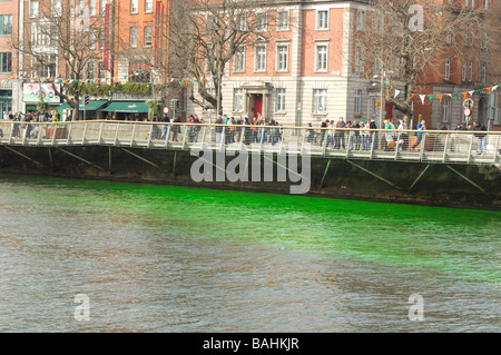 La foule célébrant au bord de la rivière Liffey et teint en vert sur St Patrick's day, Dublin, Irlande Banque D'Images