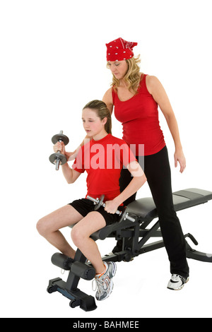 Caucasian mother helping her préadolescent fille à soulever des poids à l'aide d'un haltère sur fond blanc Banque D'Images