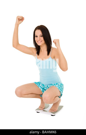 Portrait femme debout sur une échelle elle-même et de pondération très heureux Banque D'Images