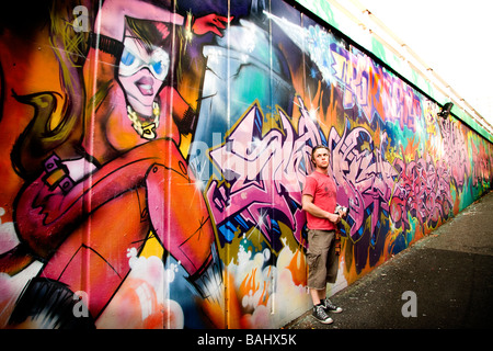 Homme debout en face de fresque graffiti à St Kilda Melbourne Banque D'Images