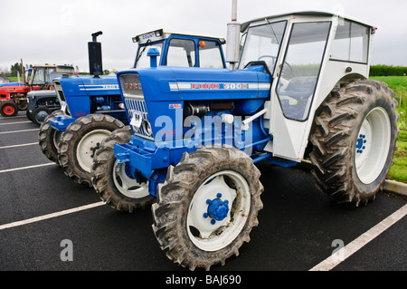 Deux tracteurs de ferme vintage Ford garée dans un parking. Banque D'Images