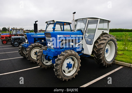 Deux tracteurs de ferme vintage Ford garée dans un parking. Banque D'Images