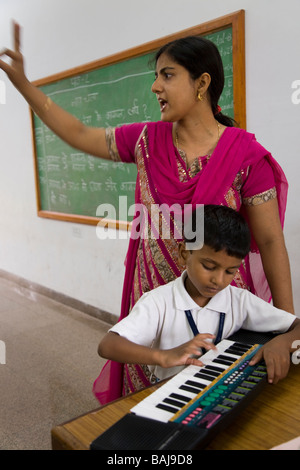 Enfants / enfants / enfants et enseignants dans un cours de musique à l'école de Hazira, près de Surat. Gujarat. Inde. Banque D'Images