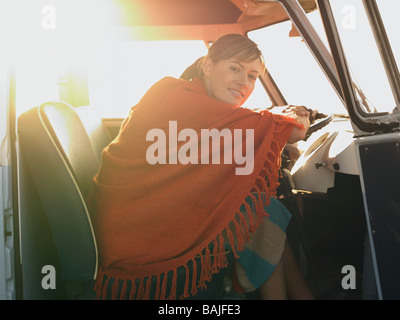 Poncho femme assis sur le siège avant du van Banque D'Images