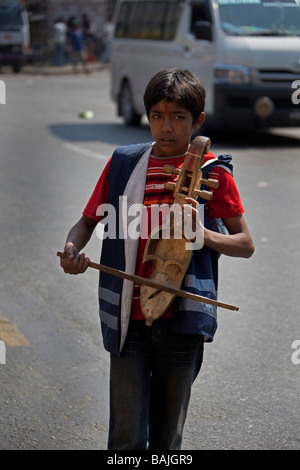 Jeune garçon au violon instrument de musique dans la rue pour l'mendier de l'argent, le Népal Katmandou Banque D'Images