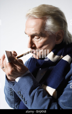 Hauts Homme portant costume et de cigare d'éclairage en studio Banque D'Images