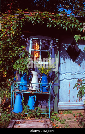 Cruches en émail bleu vintage à l'extérieur d'un abri de jardin rustique, Crozillac, Aveyron, France rurale Banque D'Images