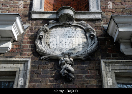 Plaque de pierre sur un mur extérieur d'hospices vert Trinity à Mile End Road London Whitechapel Banque D'Images